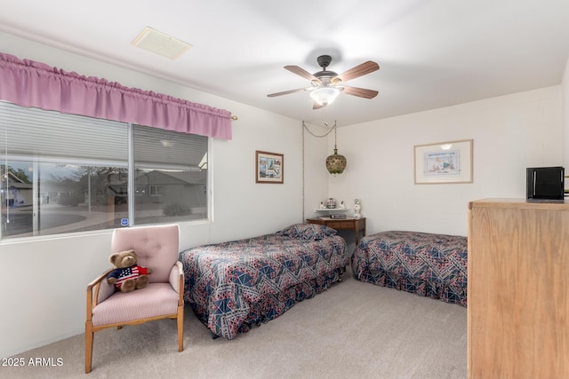 carpeted bedroom featuring ceiling fan and visible vents