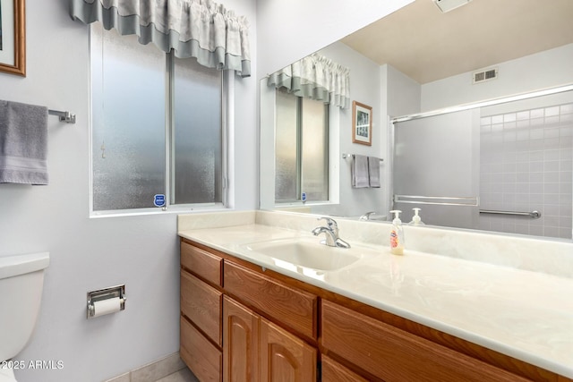 bathroom with visible vents, toilet, a shower, and vanity