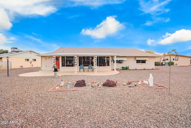 rear view of property featuring a sunroom and a patio area