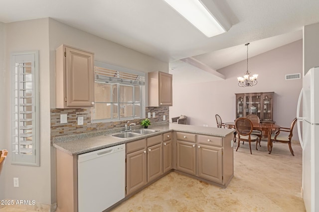 kitchen featuring white appliances, visible vents, a peninsula, a sink, and a notable chandelier