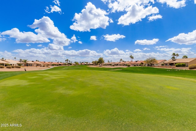 view of property's community with a residential view, view of golf course, and a lawn