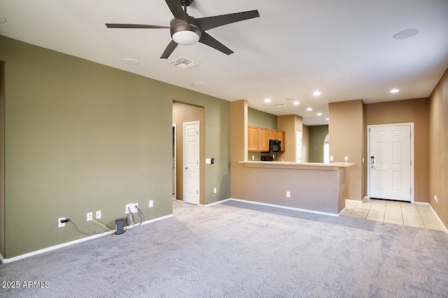 unfurnished living room with light colored carpet and ceiling fan