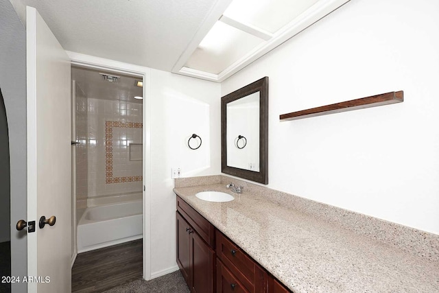 bathroom featuring vanity, tiled shower / bath combo, and hardwood / wood-style floors