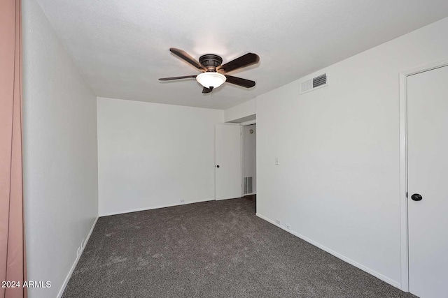 carpeted empty room featuring ceiling fan and a textured ceiling