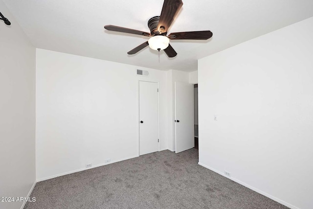 carpeted spare room featuring ceiling fan