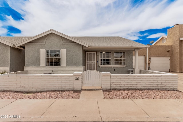 2929 E Broadway Rd Unit 30, Mesa, AZ 85204 - view of front of property featuring a gate, a fenced front yard, an attached garage, stucco siding, and driveway