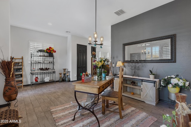 dining space featuring wood-type flooring and a chandelier