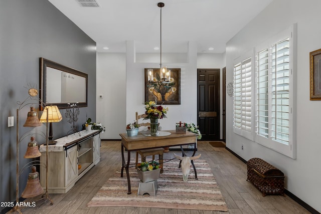 dining room featuring light hardwood / wood-style flooring and a chandelier