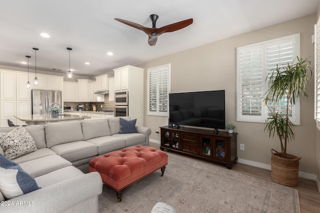 living room featuring light wood-type flooring and ceiling fan