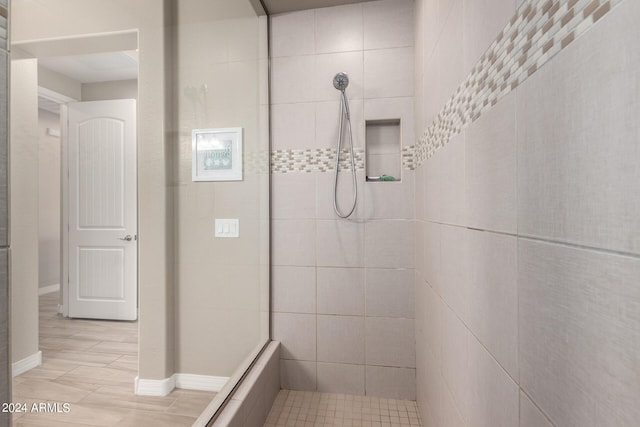 bathroom featuring a tile shower and hardwood / wood-style floors