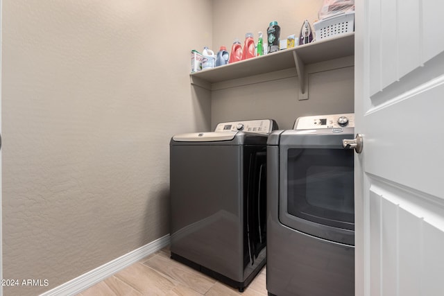 laundry area featuring light wood-type flooring and washing machine and clothes dryer