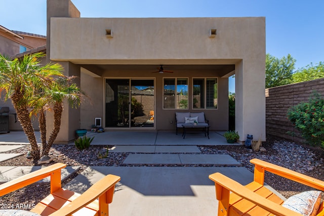 rear view of property featuring ceiling fan, an outdoor living space, and a patio