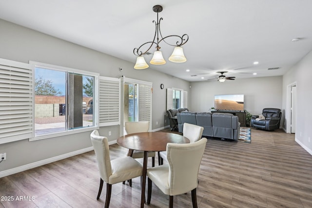 dining space with baseboards, wood finished floors, visible vents, and ceiling fan