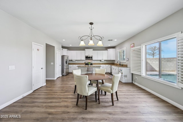 dining area with recessed lighting, a notable chandelier, wood finished floors, and baseboards