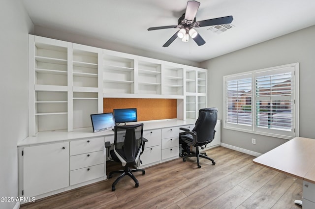 office featuring ceiling fan, visible vents, baseboards, and wood finished floors