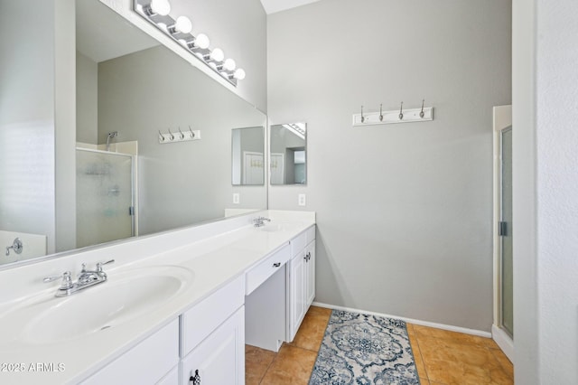 bathroom with a sink, a stall shower, double vanity, and tile patterned flooring