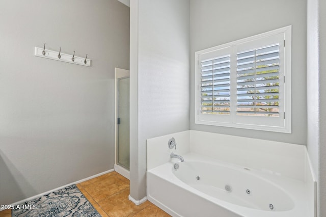 bathroom featuring tile patterned flooring, baseboards, a stall shower, and a whirlpool tub