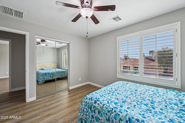 bedroom featuring wood finished floors, visible vents, and baseboards