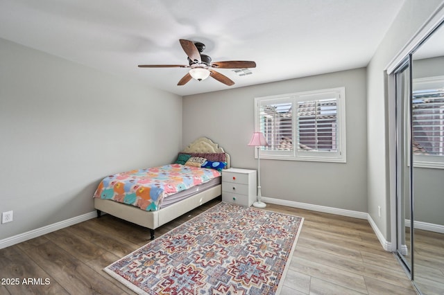 bedroom with visible vents, baseboards, a closet, and wood finished floors