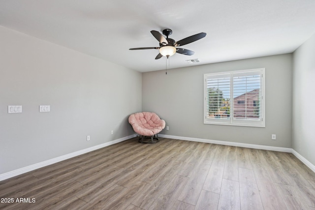 unfurnished room with visible vents, ceiling fan, baseboards, and wood finished floors