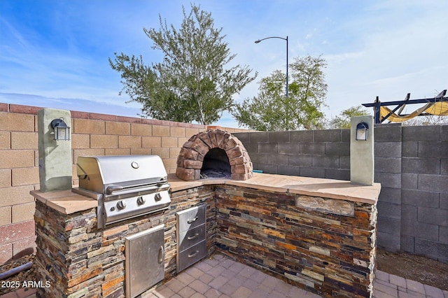 view of patio / terrace with area for grilling, exterior kitchen, and fence