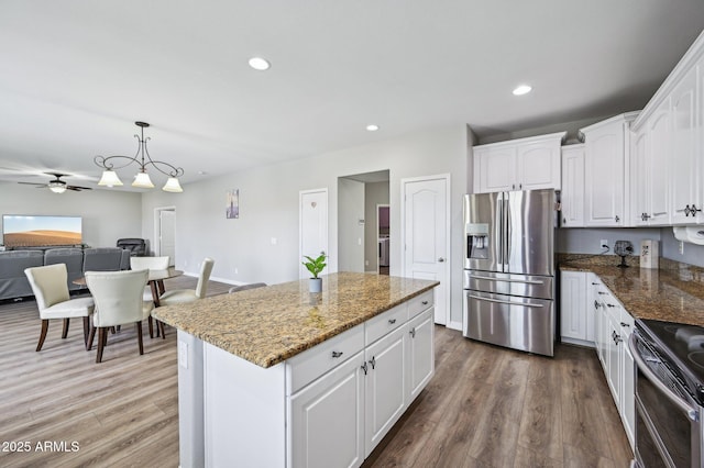 kitchen featuring recessed lighting, stainless steel appliances, wood finished floors, and white cabinetry