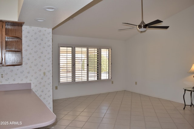 interior space with ceiling fan, light tile patterned flooring, and lofted ceiling