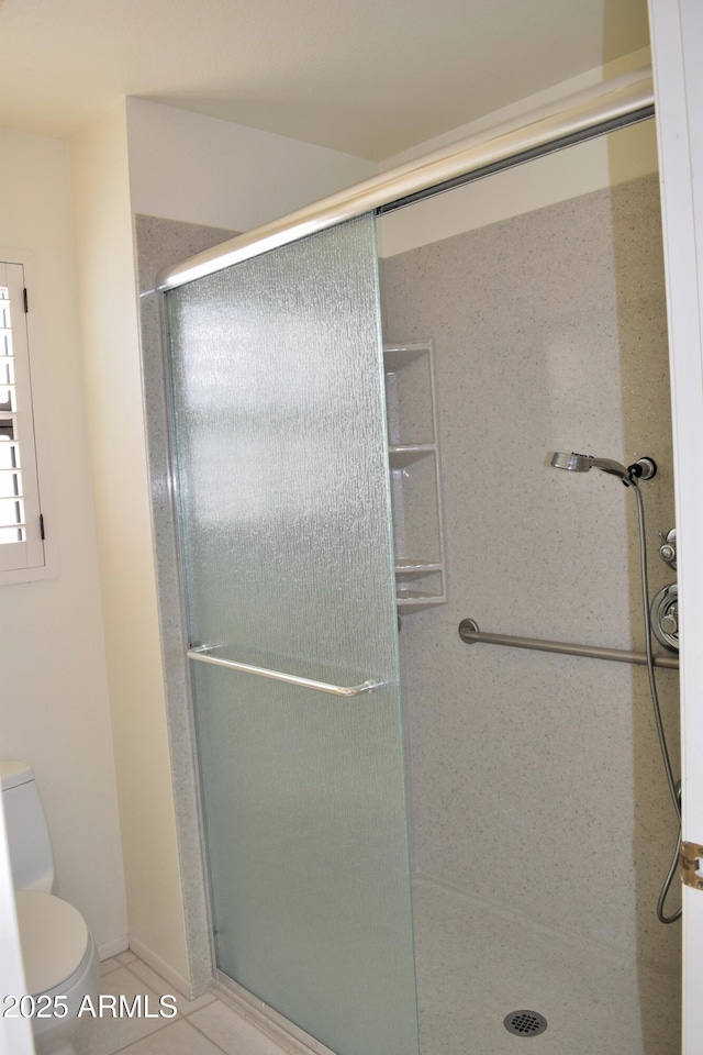 bathroom featuring toilet, tile patterned floors, and walk in shower