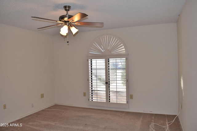 spare room featuring light carpet, ceiling fan, and a textured ceiling