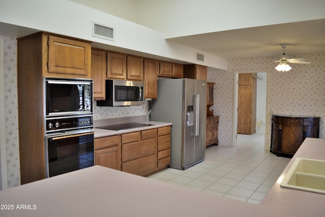 kitchen with light tile patterned flooring, sink, ceiling fan, and black appliances