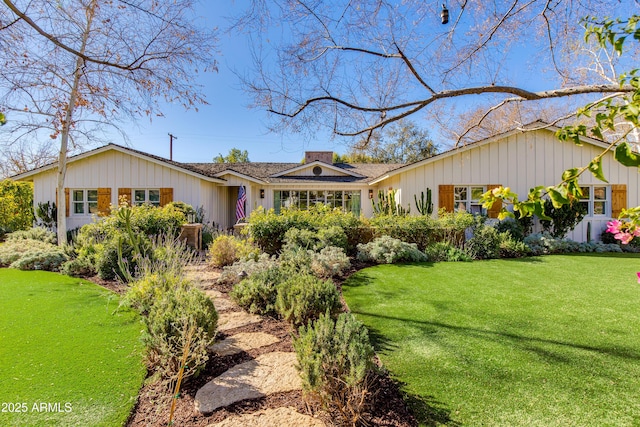 ranch-style house featuring a front yard and a chimney