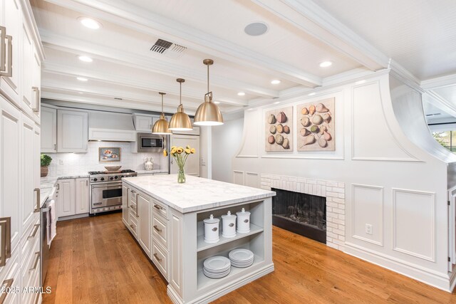 kitchen featuring open shelves, appliances with stainless steel finishes, beamed ceiling, light wood-type flooring, and a center island