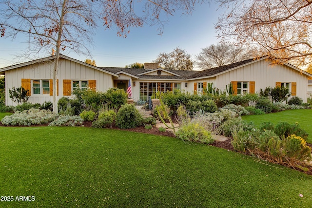 single story home with a front lawn and board and batten siding