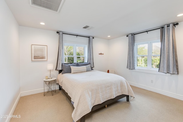 bedroom with visible vents, light colored carpet, and baseboards