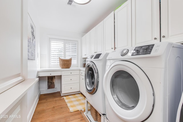 laundry room featuring cabinet space, visible vents, washing machine and dryer, and light wood-style floors