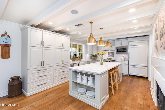 kitchen featuring beamed ceiling, visible vents, open shelves, built in appliances, and a kitchen breakfast bar