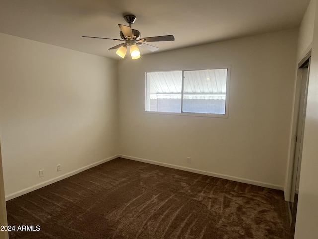 unfurnished bedroom featuring ceiling fan and dark carpet