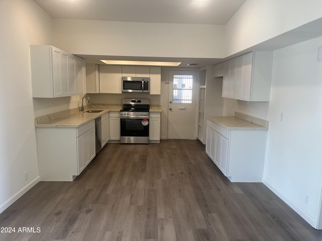 kitchen featuring appliances with stainless steel finishes, dark hardwood / wood-style floors, white cabinetry, and sink