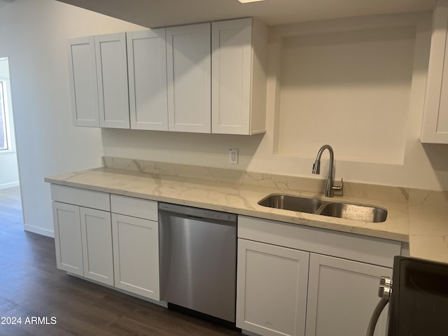 kitchen with sink, stainless steel dishwasher, dark hardwood / wood-style floors, light stone counters, and white cabinetry