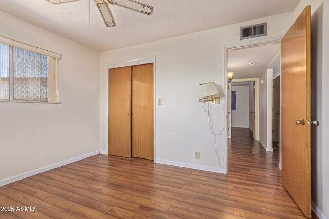 5309 E Butte St, Mesa, AZ 85205 - unfurnished bedroom featuring wood-type flooring, a closet, and a ceiling fan