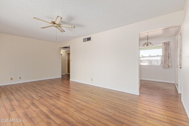 5309 E Butte St, Mesa, AZ 85205 - unfurnished room with a textured ceiling, light wood-type flooring, ceiling fan, and a chandelier