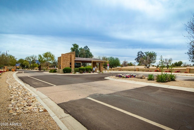 view of street with street lights, curbs, a gated entry, and traffic signs