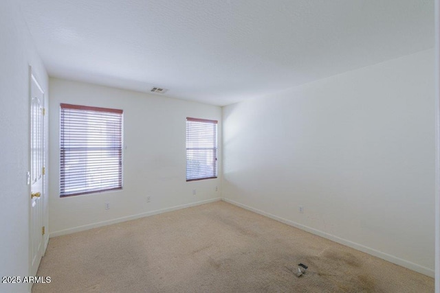 unfurnished room featuring light colored carpet