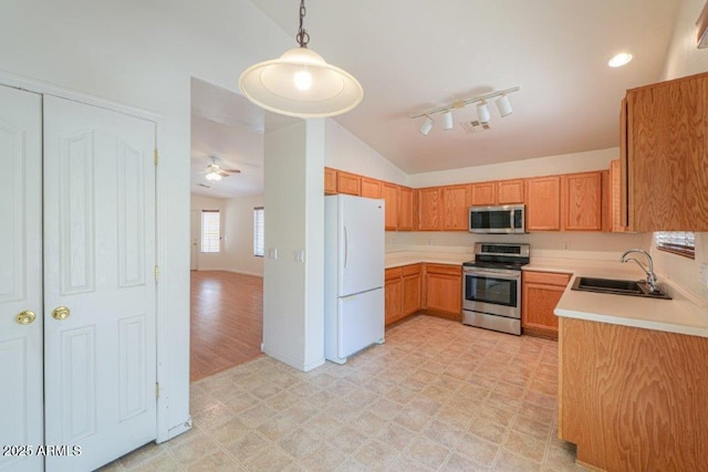 kitchen featuring ceiling fan, sink, vaulted ceiling, decorative light fixtures, and appliances with stainless steel finishes