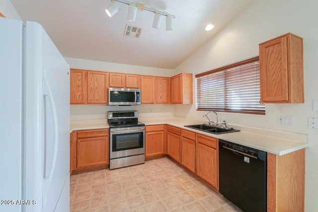 kitchen with appliances with stainless steel finishes, lofted ceiling, and sink