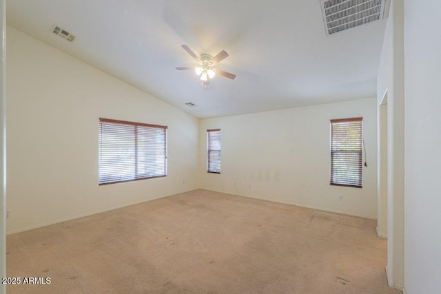 spare room featuring plenty of natural light, light carpet, and vaulted ceiling