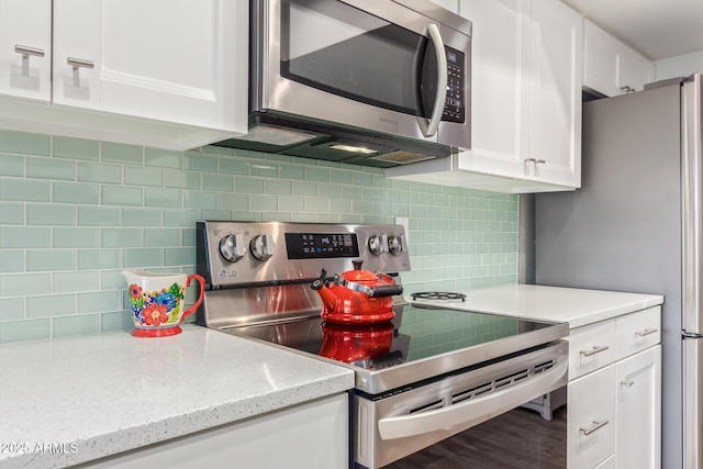 kitchen featuring white cabinets, stainless steel appliances, and tasteful backsplash