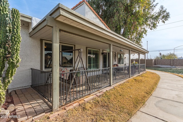 view of side of property featuring covered porch