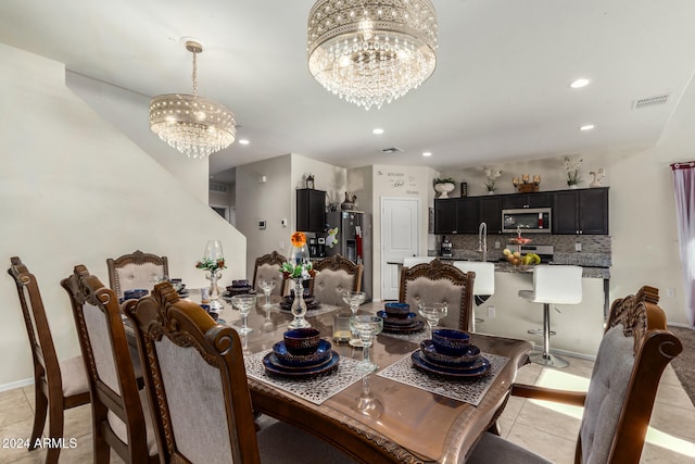 dining space with sink, light tile patterned floors, and a chandelier