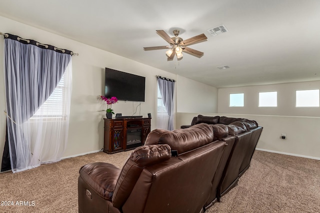 carpeted living room with ceiling fan, a fireplace, and plenty of natural light